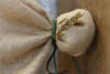 Μπομπονιέρα γάμου με οργάντζα και λινάτσα σε φυσικό χρώμα, μεταλλικό κλαδί ελιάς και διπλό κορδόνι σουέτ