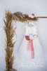 Ένα φόρεμα με βαμβακερή δαντέλα και τούλινη φούστα σε άλφα γραμμή, διακοσμητικό ζωνάκι με τρία χειροποίητα διακοσμητικά λουλούδια στην πλάτη.