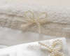 Μοναδικά απλό και κομψό βαμβακερό σετ λαδόπανων σε Ιβουάρ χρώμα με φάσα από Duchess ύφασμα.  Σατέν γκρό κορδέλα και φιογκάκι φτιαγμένο από πέρλες διακοσμούν την μέση της φάσας του λαδόπανου.